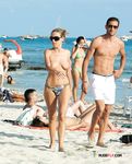 Topless e rilassate sui teli di sabbia accanto al mare calmo
