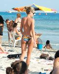 Topless e rilassate sui teli di sabbia accanto al mare calmo