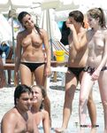 S cigaretou v ruce, topless na osušce pod sluncem