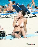 S cigaretou v ruce, topless na osušce pod sluncem