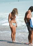 Topless procházka u oceánu v pruhovaném spodním dílu bikiny