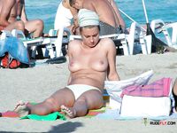 She sits completely naked sunbathing with her perfect tits and trimmed pussy showing