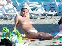 She sits completely naked sunbathing with her perfect tits and trimmed pussy showing