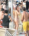 Tan Skin, Orange Bottoms, and Shoreline Calm at a Topless Beach