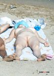 Nude Beach Walkers Follow the Sandy Path With Waves at Their Side