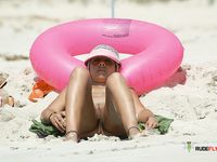 Nude Sunbathing on White Sand With Blue Water Behind
