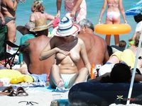 Tavola da surf, tenda e mare calmo su una spiaggia nudista