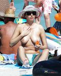 Tavola da surf, tenda e mare calmo su una spiaggia nudista