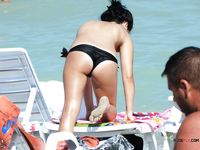 Tavola da surf, tenda e mare calmo su una spiaggia nudista