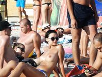 Slip a stelle in spiaggia topless tra altri abbronzati