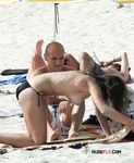 Multiple girls walk around or sit in the sand topless, with their amazing, natural breasts on display 2