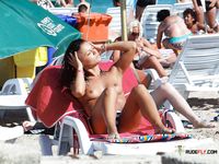 Two hot nudist chicks sunbathe their sexy asses at the beach 2
