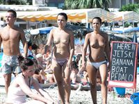 Slip bikini colorati e onde sullo sfondo della sua passeggiata topless