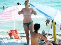 One Woman Topless on a Beach Towel by a Stone Wall