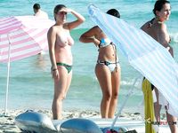 One Woman Topless on a Beach Towel by a Stone Wall