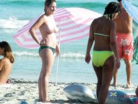 One Woman Topless on a Beach Towel by a Stone Wall