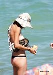 Chapeau de soleil et serviette à motifs, un instant nu à la plage