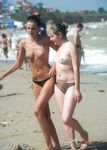 Cueca estampada e passos em conjunto na caminhada de casal na praia nudista