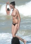 Cueca estampada e passos em conjunto na caminhada de casal na praia nudista