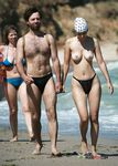 Cueca estampada e passos em conjunto na caminhada de casal na praia nudista