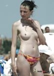 Two dark-haired hotties sit in the sand topless, tanning their slim bodies and firm tits 3