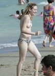 Two dark-haired hotties sit in the sand topless, tanning their slim bodies and firm tits 3