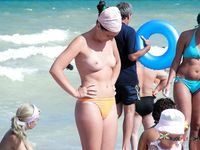 Blonde topless nudist woman enjoys her time at a nudist camp with her titties out 2