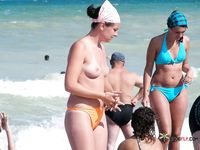 Blonde topless nudist woman enjoys her time at a nudist camp with her titties out 2