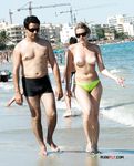 This dazzling blonde sits on the rocky beach topless and enjoys her day, unaware she's being filmed 3