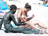 Sensual naturist babe filmed by voyeur walking around the beach naked