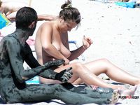 Sensual naturist babe filmed by voyeur walking around the beach naked