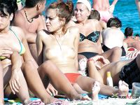 Standing Topless on the Beach in Colorful Bikini Bottoms