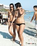 This playful brunette sits at the beach and sunbathes her beautiful, perky breasts 4