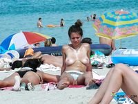 Naturist babe caught lying down and the beach and sunbathing naked