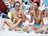 Naturist babe caught lying down and the beach and sunbathing naked