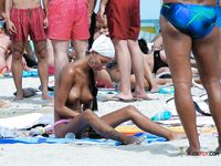 Naturist babe caught lying down and the beach and sunbathing naked