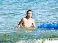 Blue Air Mattress and a Nude Beach Swimmer in Shallow Water