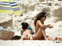 Unaware nudist babes secretly filmed by a voyeur while sunbathing at the beach