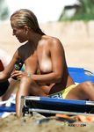 Buntes Schwimmtier in der Hand beim Waten am Nacktstrand