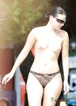 Buntes Schwimmtier in der Hand beim Waten am Nacktstrand