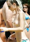 Nude Sunbathing on a Beach Towel Beside Sand and Greenery