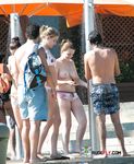 Gestreepte bikinibroekjes tijdens een zonnige topless wandeling over buiten trapjes
