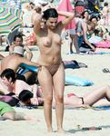 Splashing Waves Around Her Feet in Shallow Topless Beach Water