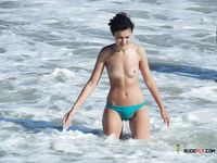 Voluptuous naturist couple enjoys their time at the beach as they go for a swim and cuddle on the towels