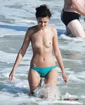 Voluptuous naturist couple enjoys their time at the beach as they go for a swim and cuddle on the towels