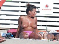 Voluptuous naturist couple enjoys their time at the beach as they go for a swim and cuddle on the towels