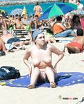 Dove la sabbia incontra il mare in una giornata luminosa con una bagnante topless