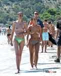 Dove la sabbia incontra il mare in una giornata luminosa con una bagnante topless