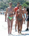 Dove la sabbia incontra il mare in una giornata luminosa con una bagnante topless