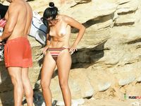 Two hot chicks, a blonde and a brunette are fully naked and enjoy lying at the beach in a nudist resort, while they feel the Sun heat on their bodies 2